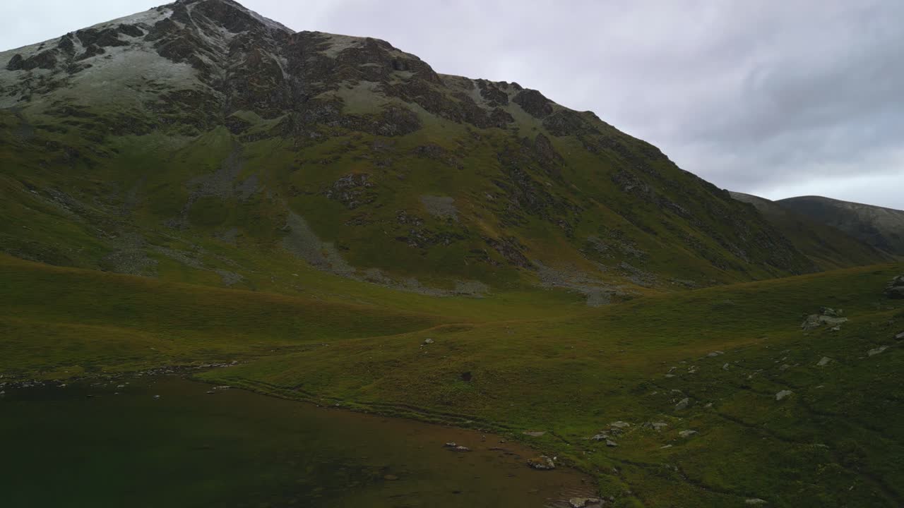 Grande vetta montana che emerge dai pendii verdi circostanti