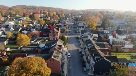 aerial establishing shot, dolly forward of traffic passing through town in usa