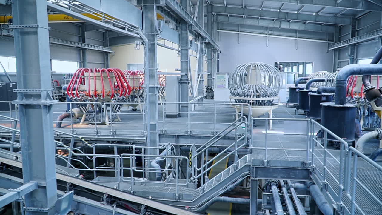 Moving up conveyor belt with kaolin clay. Steel tubes and pipes at the equipment for clay processing.