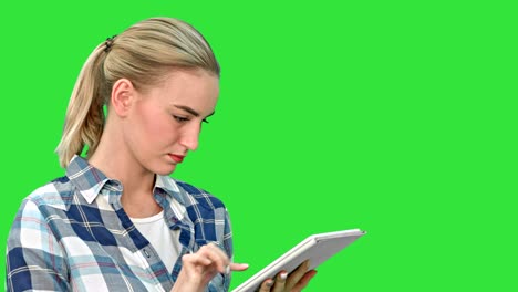 portrait of a young woman using a tablet on a green screen, chroma key