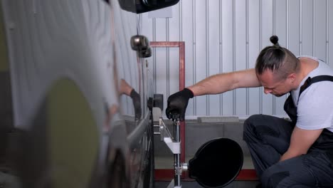 mechanic performing wheel alignment on a car