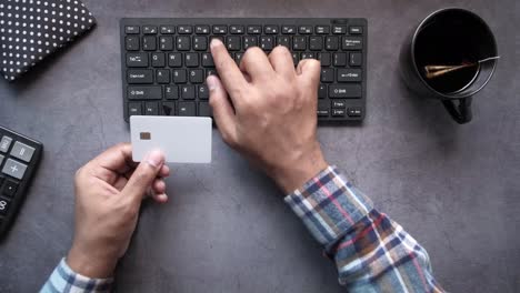 person using a credit card on a computer keyboard