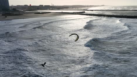 extreme sport kitesurfer does huge kiteloop in stormy waves