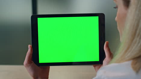 closeup lady watching greenscreen tablet at office. woman hands holding computer