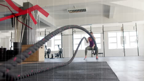 Animation-of-graph-processing-data-over-caucasian-woman-cross-training-with-battle-ropes-at-gym