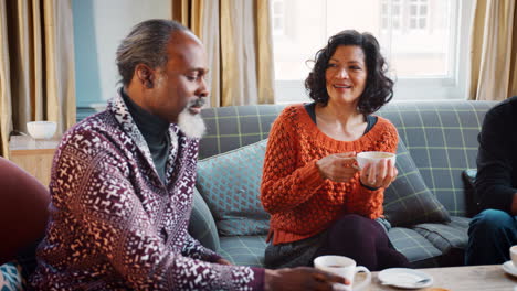 Group-Of-Middle-Aged-Friends-Meeting-Around-Table-In-Coffee-Shop