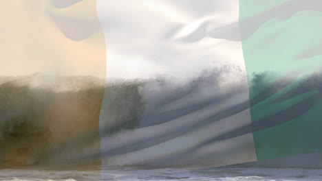 digital composition of waving ivory coast flag against waves in the sea