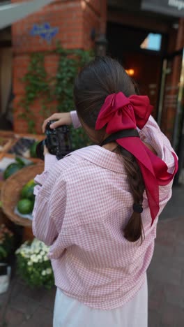 woman taking picture of fresh produce outside a cafe