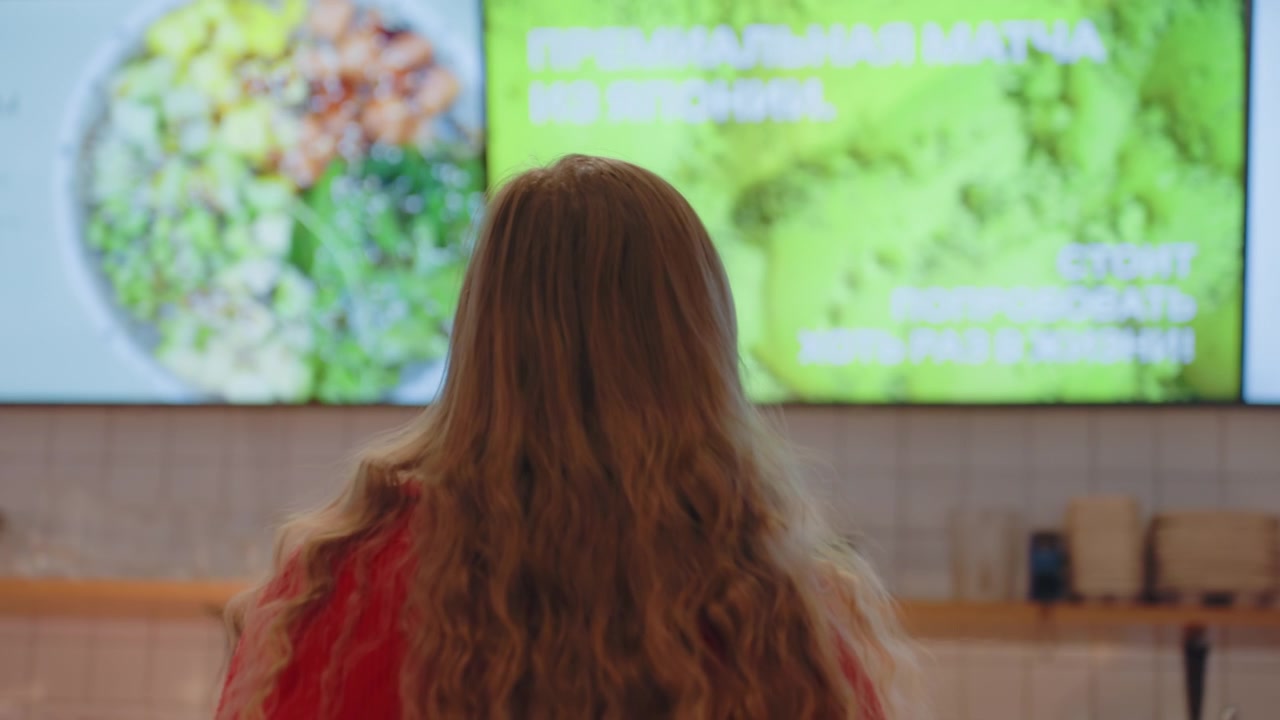 Giovane donna che guarda il menu digitale in una caffetteria