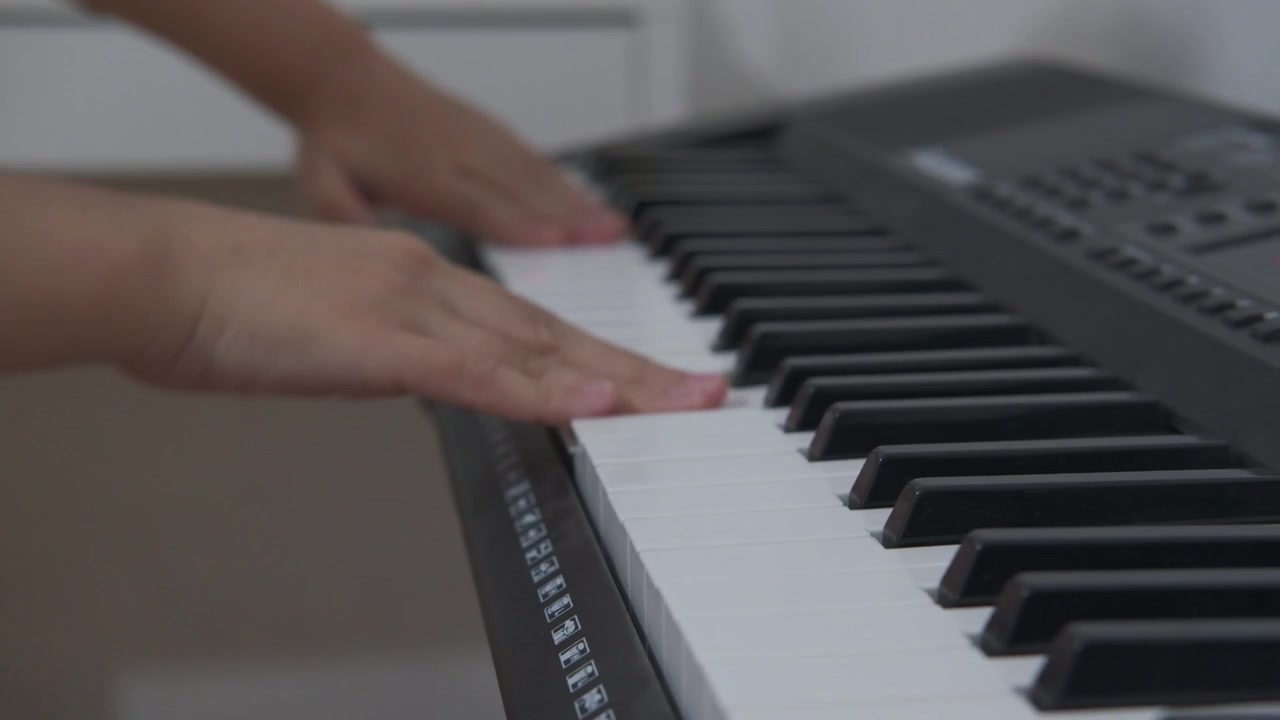 Mani che premono accordi, battono sui tasti della tastiera, scivolano, movimenti casuali sul pianoforte.