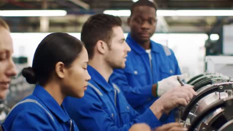 engineers and technicians assembling machinery in a factory