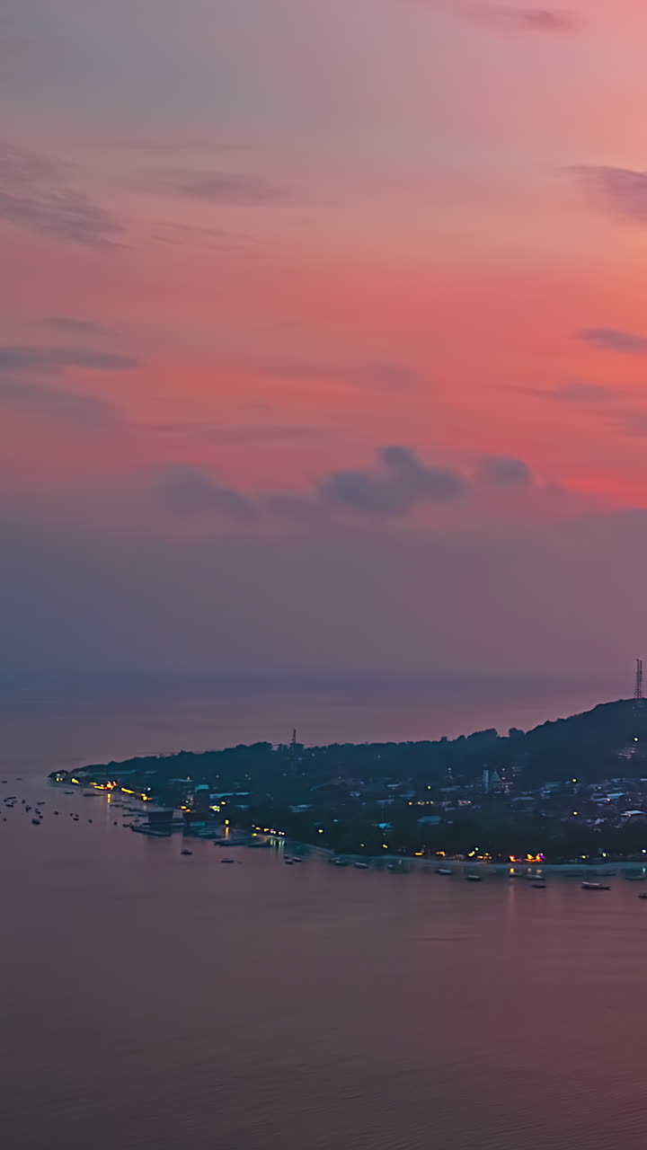Sunset to twilight time-lapse of Bali coastline at dusk with warm orange glow in sky, vertical