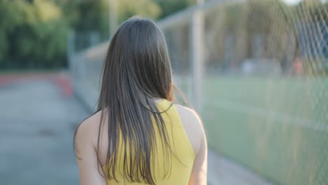 woman jogging on outdoor track in sportswear at athletic field