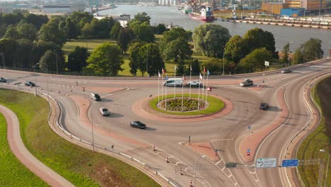 Aerial-shot-of-a-roundabout-with-cars-and-country-flags-in-the-middle