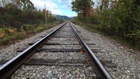 FPV-Drohnenflug-In-Geringer-Höhe-über-Bahngleise,-Farbenfroher-Herbstwald-Daneben