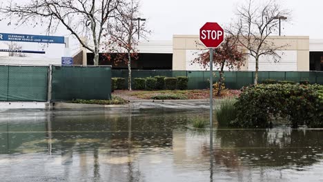 Graves-Inundaciones-En-Una-Señal-De-Alto-Durante-La-Lluvia-Y-La-Carretera-Inundada-En-San-Bernardino-California-60fps