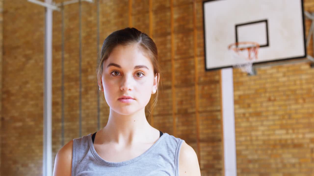 adolescente con una pelota de baloncesto en la cancha 4k