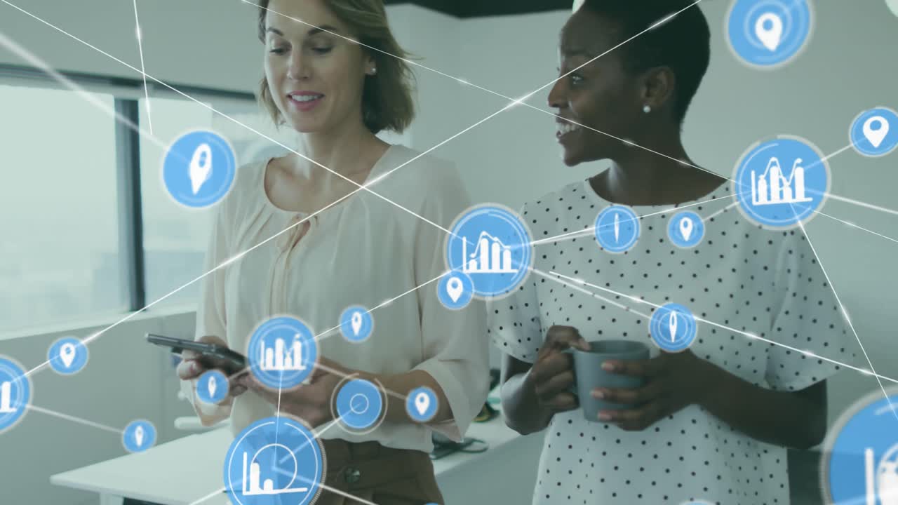 Animation of connected icons over diverse female coworkers walking and sharing ideas in office