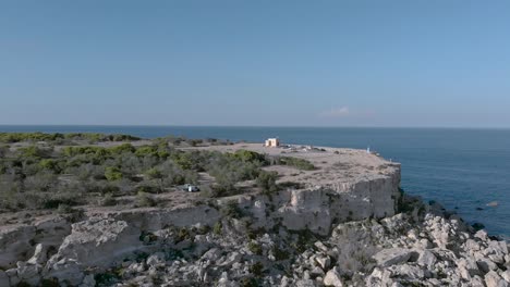 Aufnahme-über-Das-Meer,-Die-Klippen-Und-Die-Kapelle-In-Richtung-Eines-Bootes