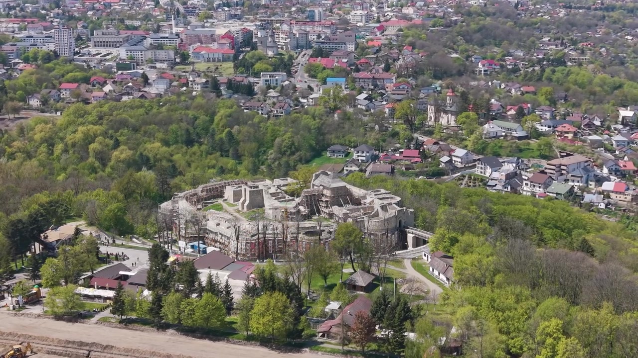 Suceava, Romanya'da yeşillikler ve şehir manzarasıyla çevrili Suceava Kalesi'nin drone görüntüsü
