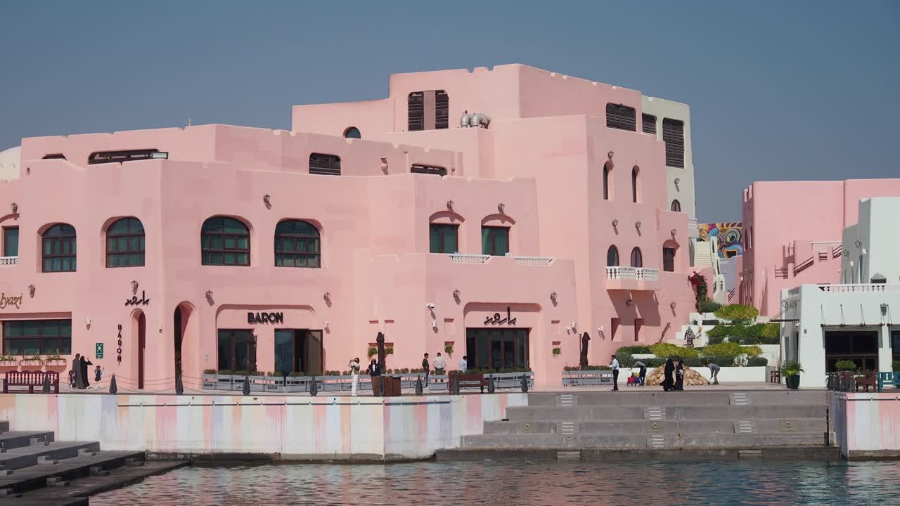 아마도 중동 도시에 있는 해안가에 있는 분홍색 건물들
