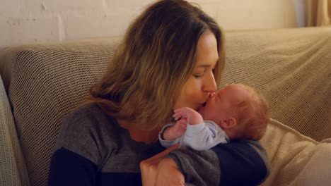 Mother-kissing-her-baby-boy-in-living-room-4k