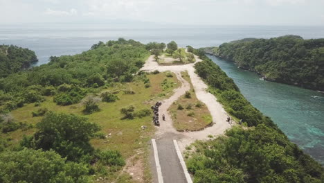 aerial moto rides past parked scooters on scenic