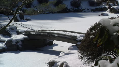 Pasarela-Cubierta-De-Nieve-Se-Extiende-Por-Un-Estanque-Congelado-En-Invierno