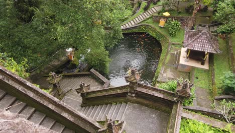 Aerial-View-of-Balinese-Mengening-Temple-Religious-Hindu-Stone-Architecture-Site-in-Tropical-Jungle-of-Bali-Indonesia,-Water-Pond