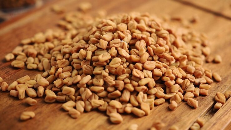 Pile of Dried Fenugreek Seeds on a Wooden Cutting Board