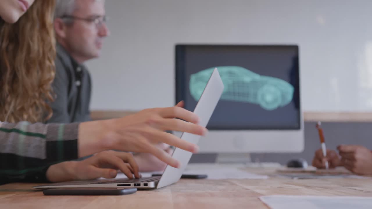 dos mujeres y un hombre trabajando en una oficina creativa