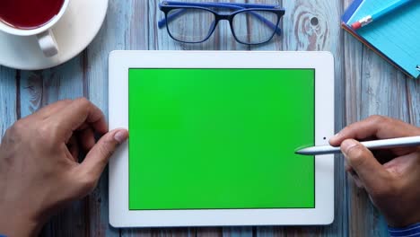 persona que utiliza una tableta con una pantalla verde