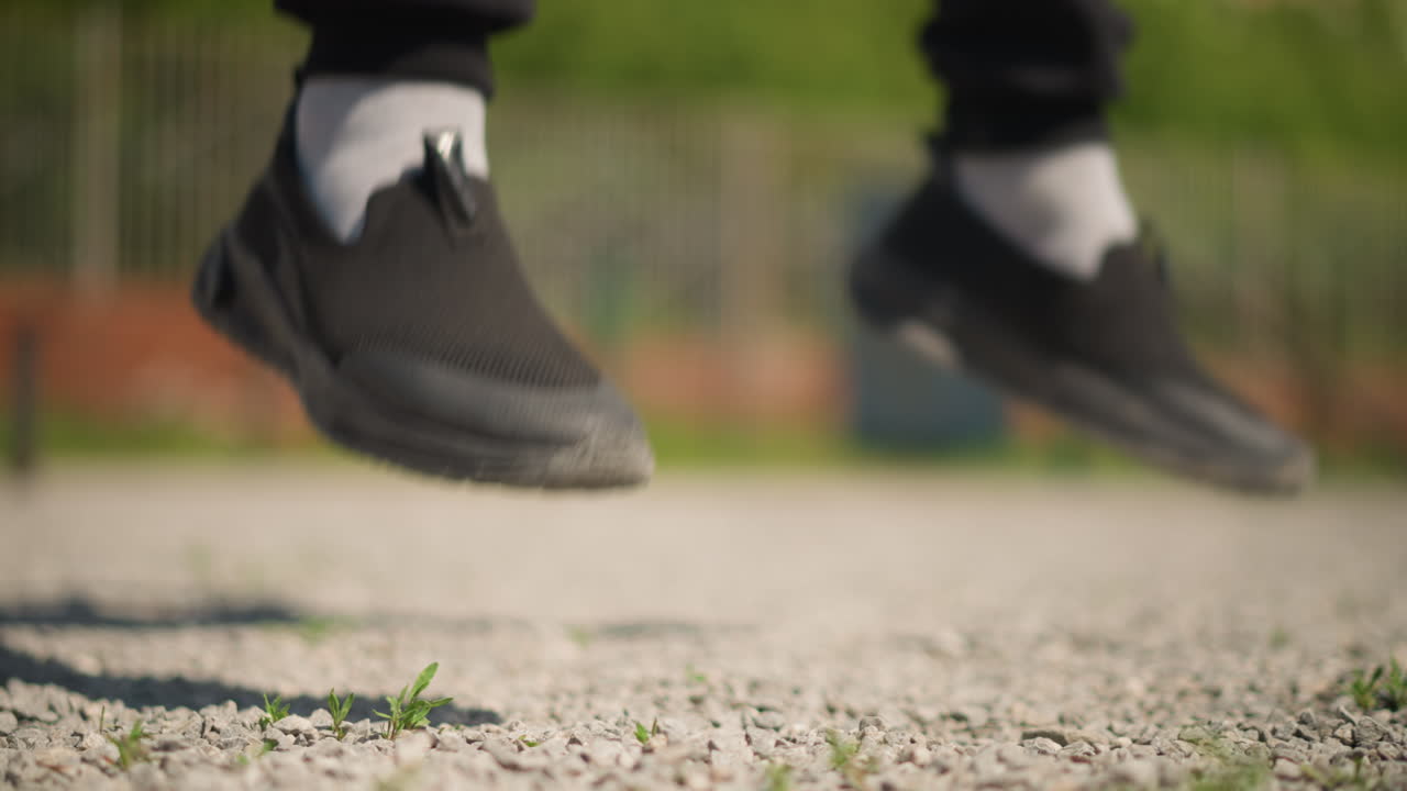 トレーナーが屋外で素早いドリルを実施、人が悪路で俊敏性トレーニングを行い、アスリートが屋外トレーニングセッション中にスピーディーなフットワークとダイナミックなコントロールを披露