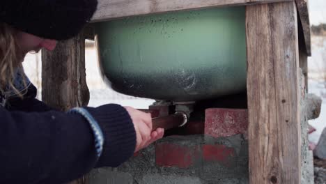 A-Man-is-Placing-a-Pipe-Beneath-the-DIY-Hot-Tub---Close-Up