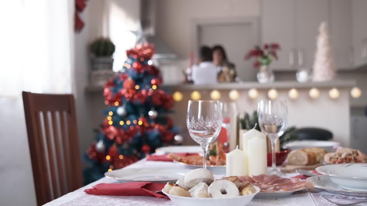 Christmas decorations on the table while a boy sets the table to eat