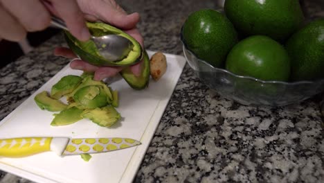 healthy diet: male hands prepare fresh avocado for cooking