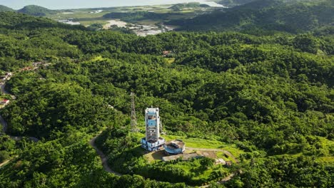 aerial pullback of pagasa weather radar station atop hills overlooking the lush tropical island catanduanes, philippines during daytime