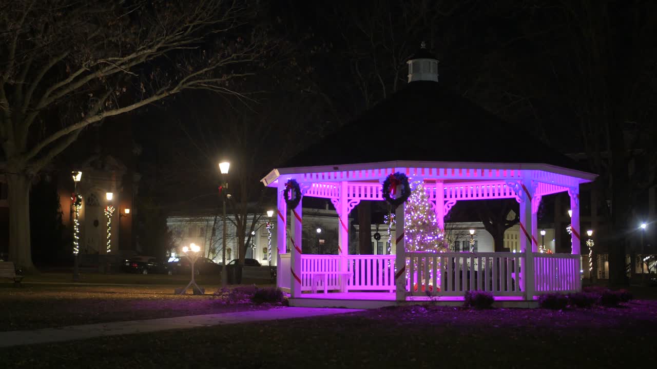 A Wooden Shed Decorated With Wreath And String Lights During Christmas Season