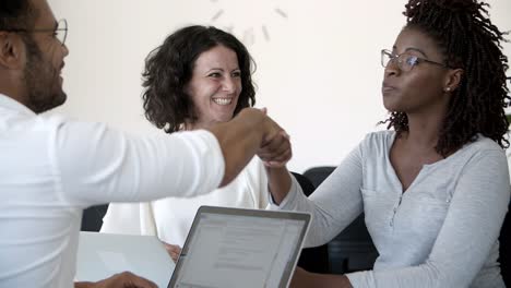 satisfied woman with toothy smile shaking hands with young man