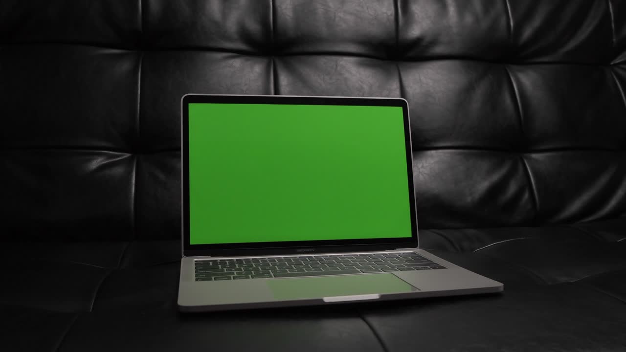 Ripresa con slider di un notebook moderno bianco sul divano con sfondo verde
