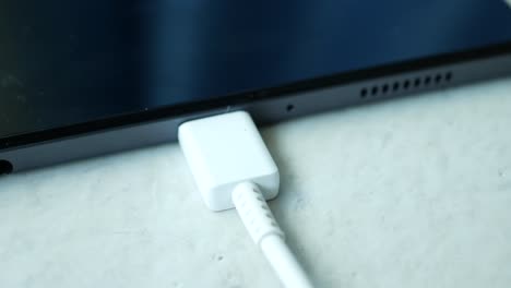 charging s digital tablet with a cable on white background ,