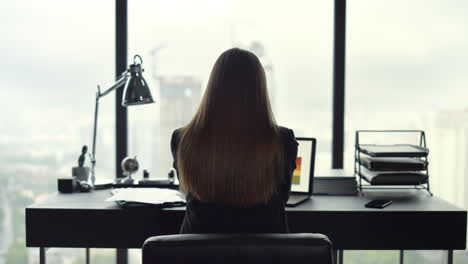 Businesswoman-analyzing-business-graphs-on-laptop.-Worker-celebrating-success