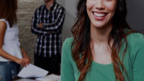 animation of graphs and trading board, biracial smiling businesswoman with coworkers in background