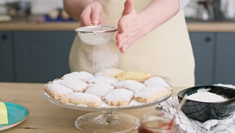 video of woman sprinkling and decorating cookies with powdered sugar