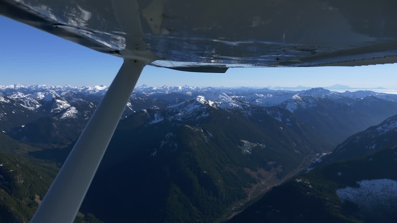 vista panorámica de exuberantes montañas cubiertas de nieve desde la ventana del avión cessna-172 en vuelo desde vancouver a pemberton en columbia británica, canadá