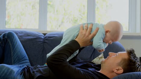 padre jugando con su bebé en la sala de estar 4k