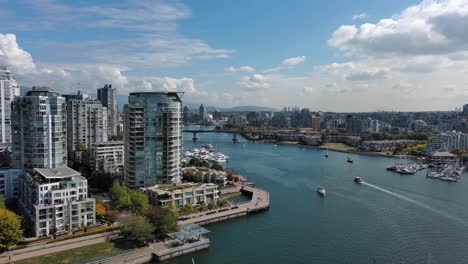 drone shot of the sea wall in yaletown downtown vancouver including false creek, buildings, boats, trees, bridge during summer