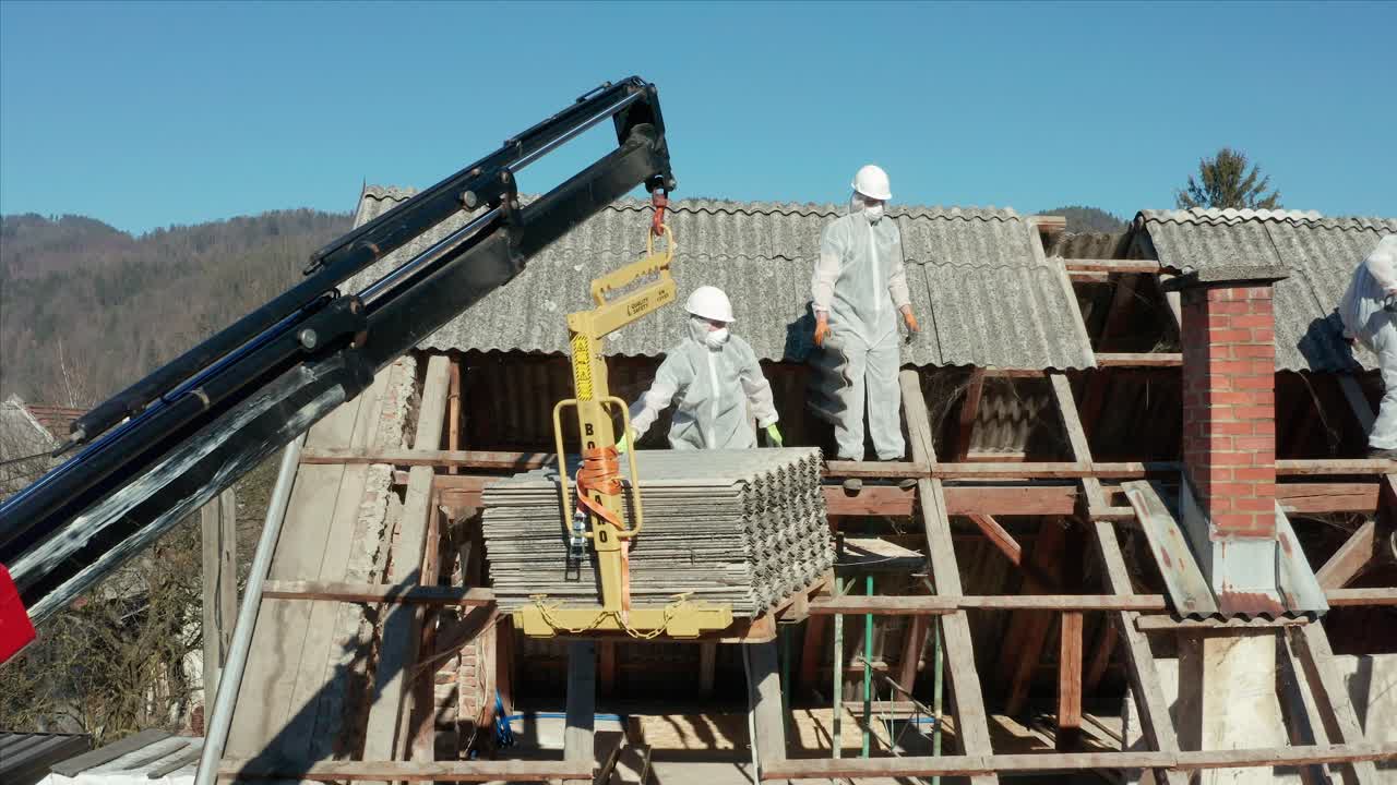 hombres en el trabajo quitando las tejas del techo de una casa para su renovación