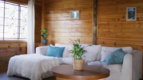 vista general de la sala de estar con sofá y mesa de café en una cabaña de madera, cámara lenta