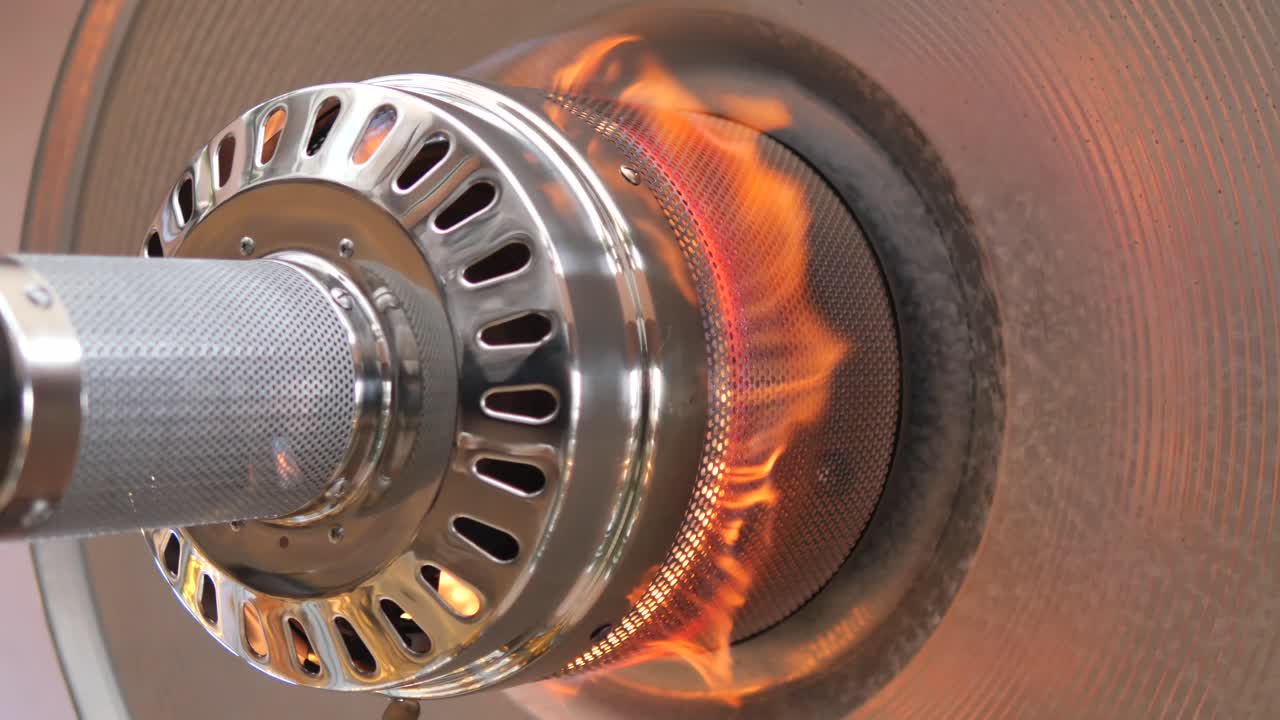 Primo piano di fiamme che bruciano all'interno di un riscaldatore da esterno